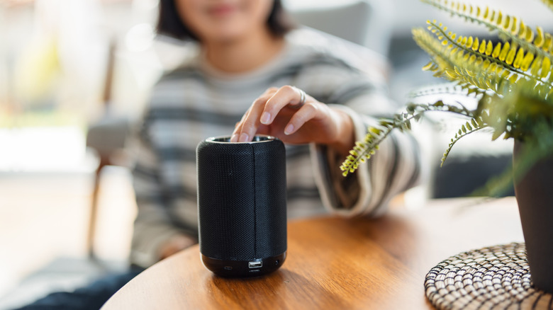 Woman turning on Bluetooth speaker