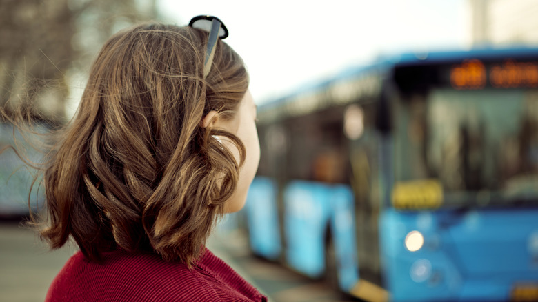 Woman looking at blue bus