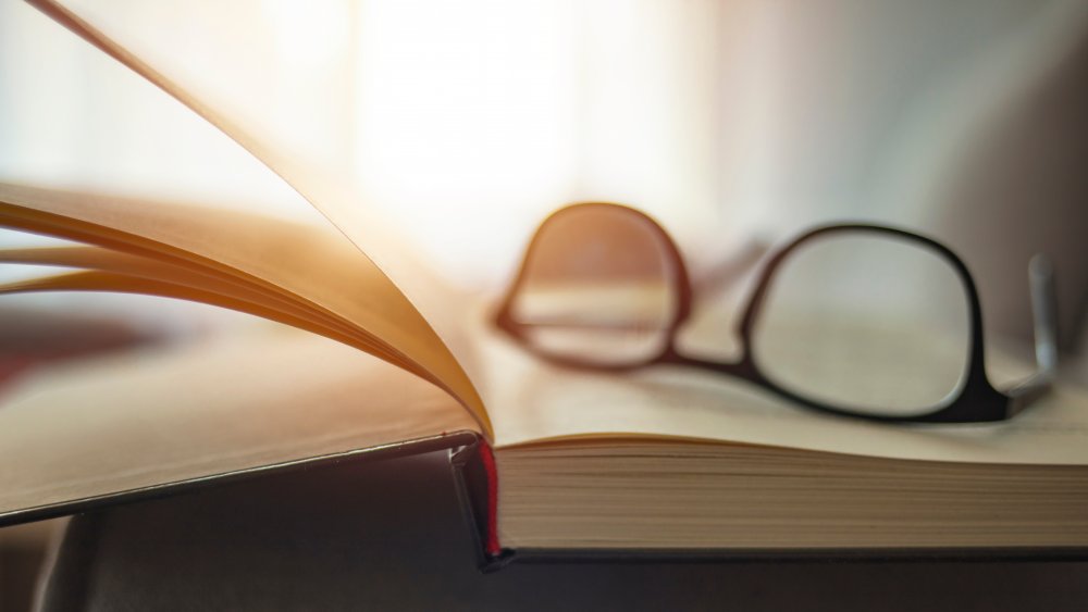 A pair of glasses sits on top of a book