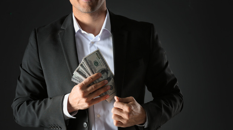 A man pocketing a stack of cash