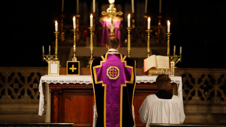 priest conducts mass at altar