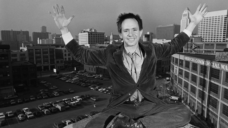 A smiling Peter Ivers poses on roof of L.A. apartment, 1981