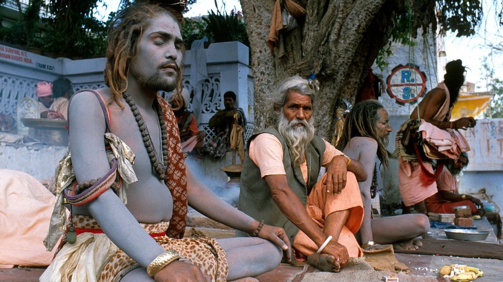 Hindu holy men in India praying, covered in ash