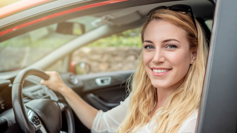 Smiling woman behind wheel of car