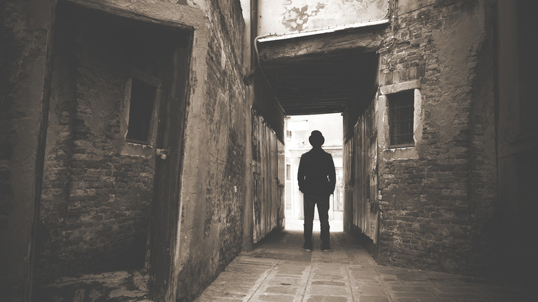 Silouette of man in alley with tophat