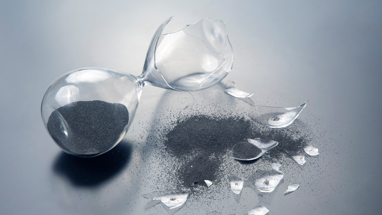 Broken hourglass spilling sand