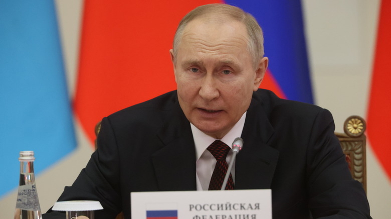 vladimir putin sitting near microphone