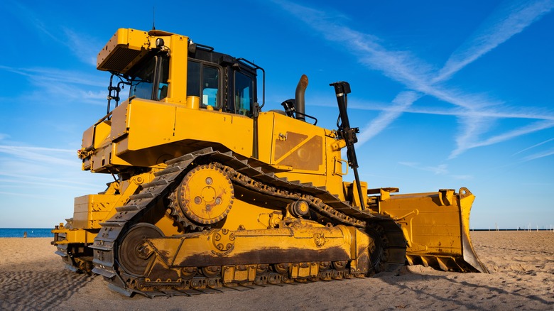 stock image of bulldozer on dirt in front of blue sky
