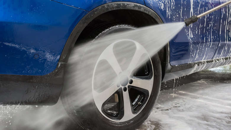 A car tire being washed with pressure hose