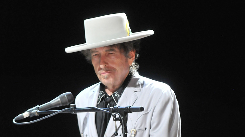 Bob Dylan in white outfit and hat with microphone