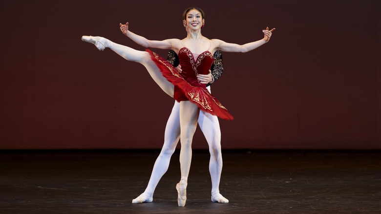 two ballerinas posing together on stage at bolshoi leg raised