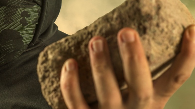 person with brick in hand