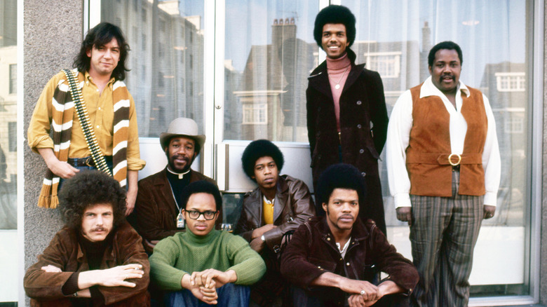 Eric Burdon and War posing in front of a building.