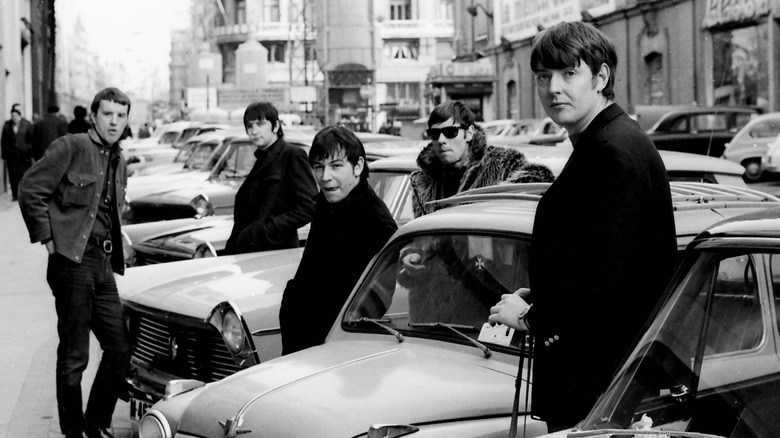 The members of the Animals posing on a street among cars in Spain.