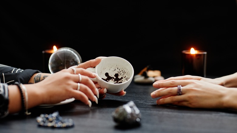Hands and cup with tea leaves