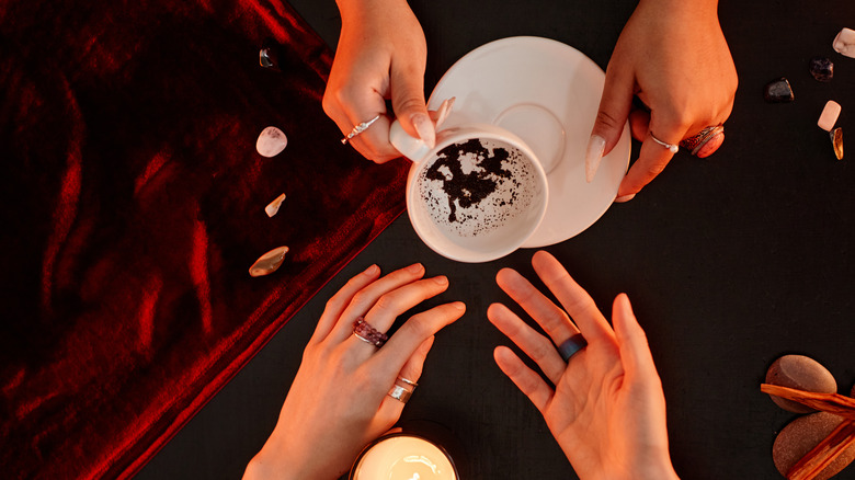 Two hands serve tea cup