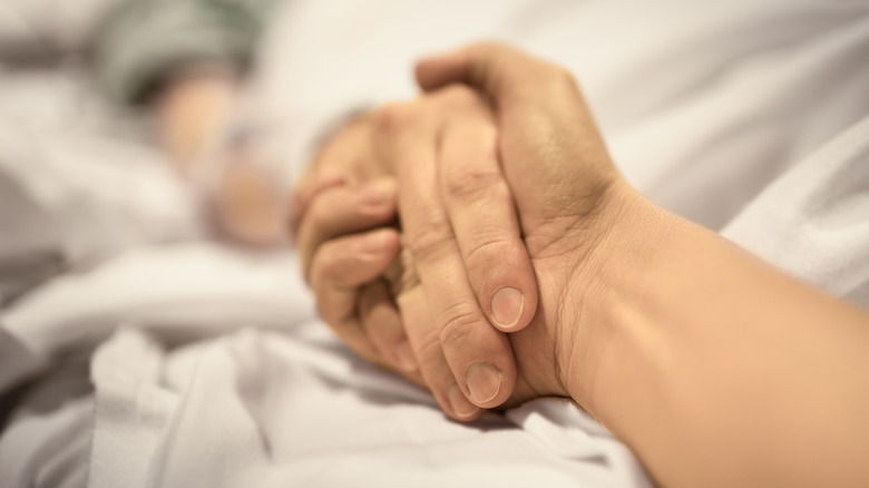 two people holding hands hospital