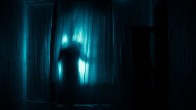 Dark figure at window at night
