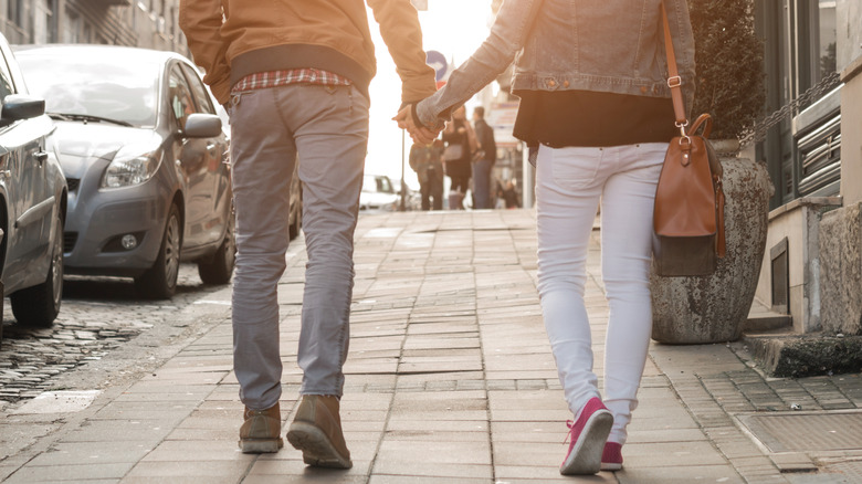 couple holding hands while walking