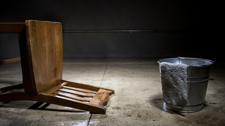 chair and bucket in stark room