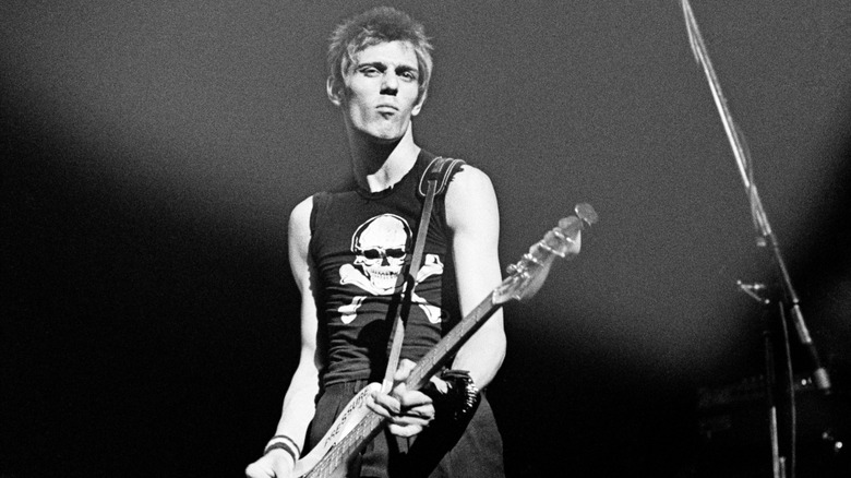 Paul Simonon playing guitar on stage