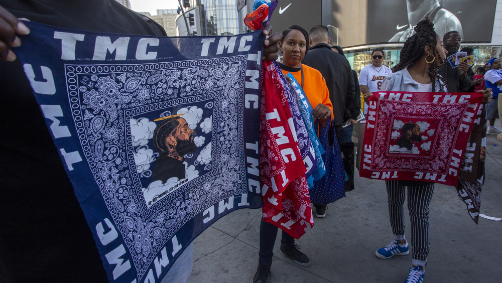 People sell memorial bandanas in the colors of Crips and Bloods 