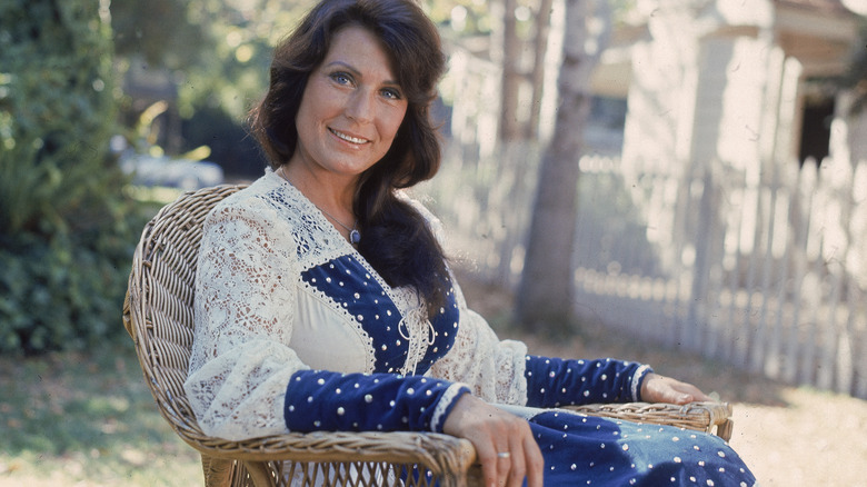 Loretta Lynn poses in chair