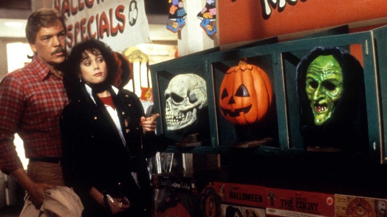 Tom Atkins and Stacey Nelkin next to Halloween masks