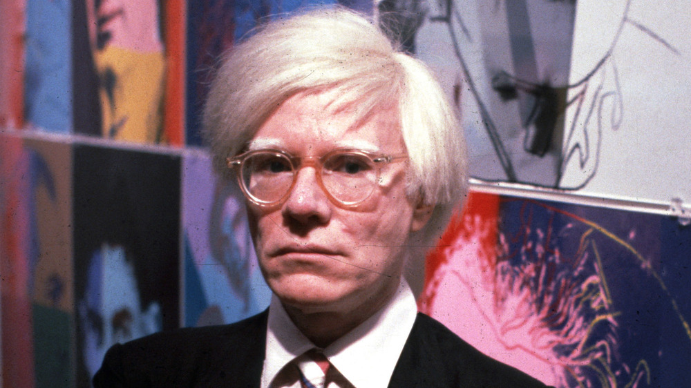 Andy Warhol with his paintings