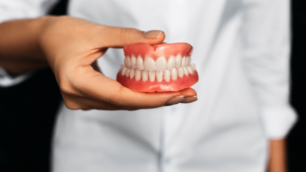 Dentist holding dentures