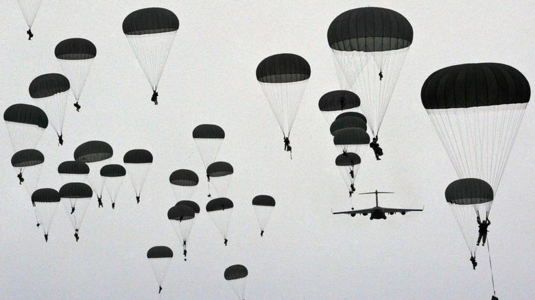 Army paratroopers parachuting with aircraft