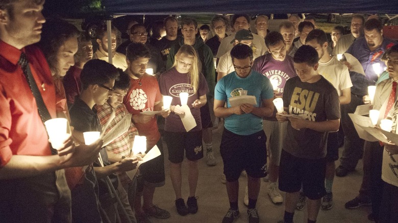 Students holding candles group vigil