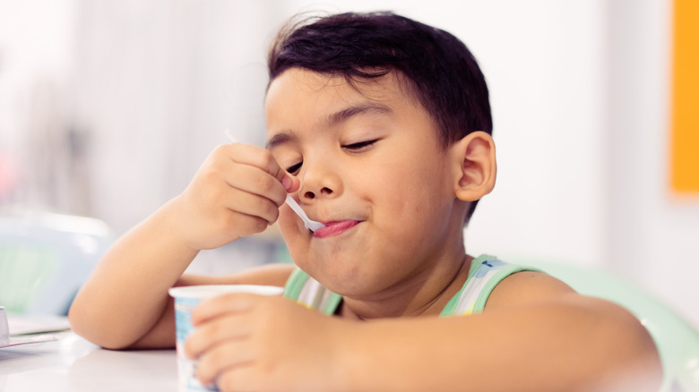 Young boy eating pudding