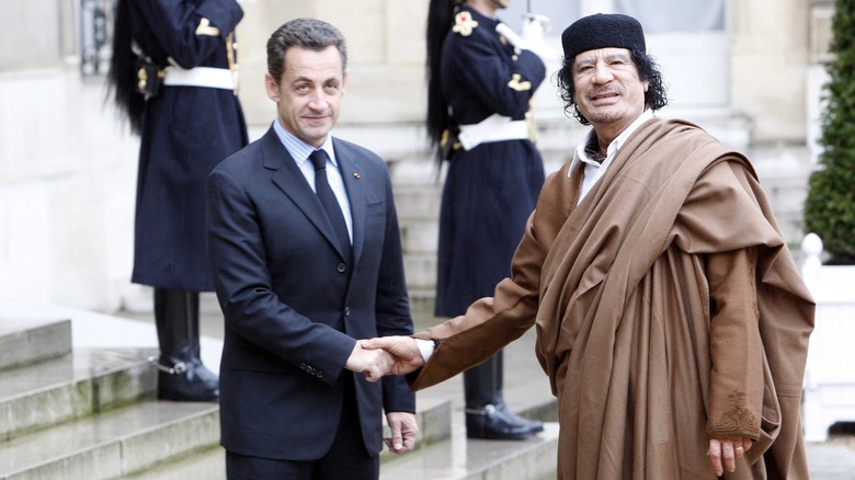 Muhammad Gaddafi shakes Nicholas Sarkozy's hand