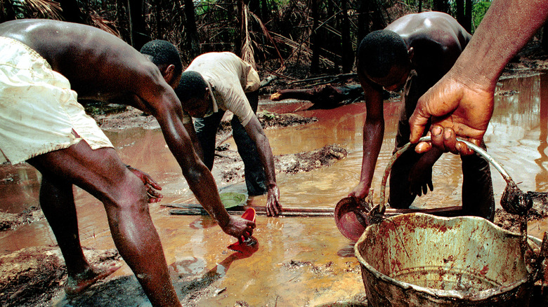 people trying to clean oil spill in nigeria