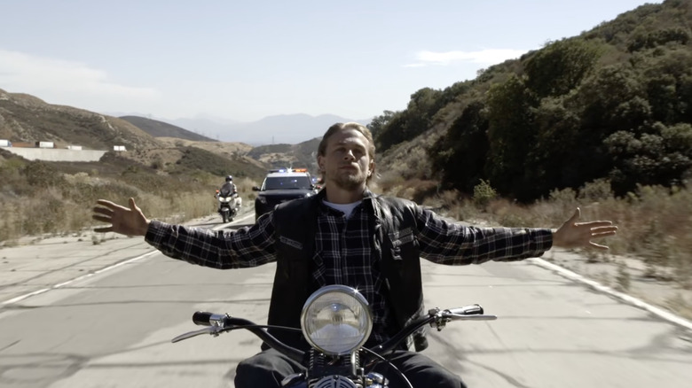 Charlie Hunnam in the series finale of Sons of Anarchy, riding a motorcycle with his arms extended