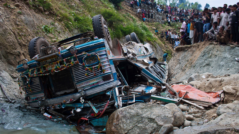 flipped over crushed blue bus