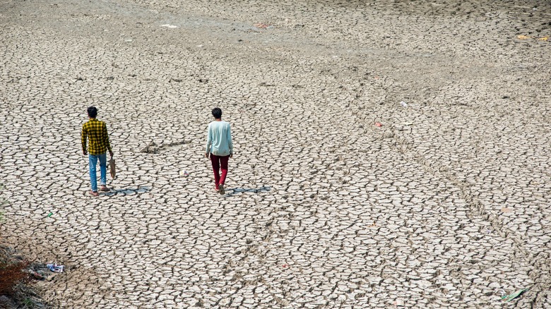 Two boys walking across a dried river