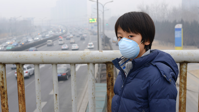 Child wearing mask in smog