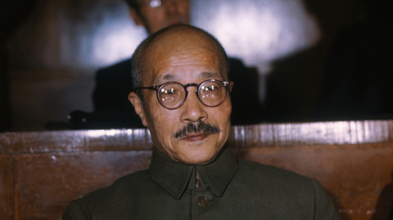 Hideki Tojo sat with glasses and moustache in brown suitd