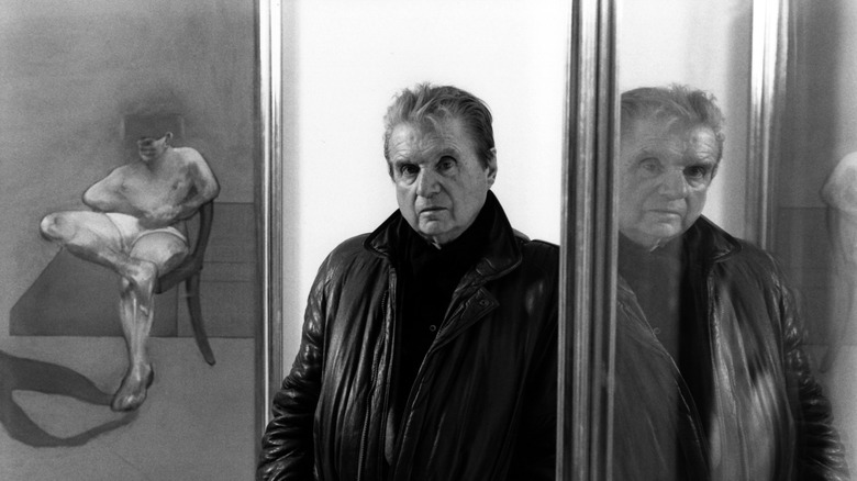 Francis Bacon standing by paintings