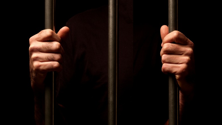 Prison bars hands