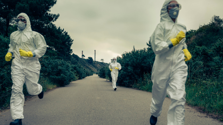 People in biological protection suits running 