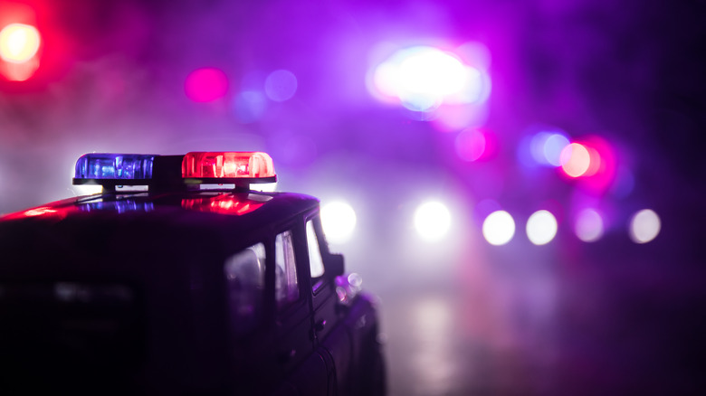 Vintage police vehicle with red and blue lights flashing 