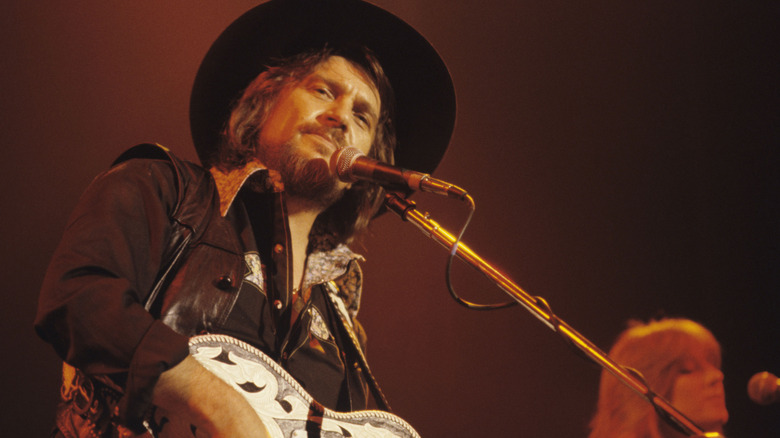 Waylon Jennings performing in front of microphone
