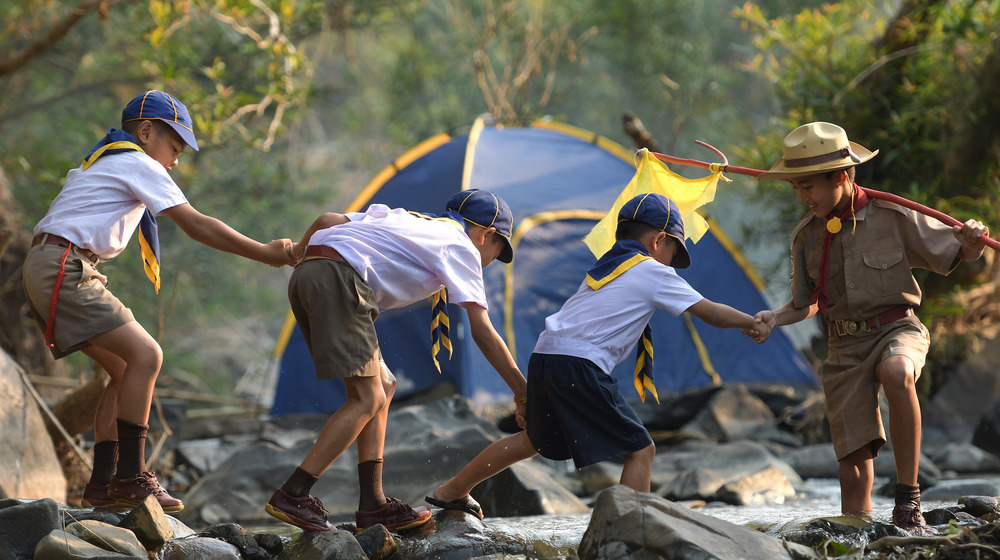 Boy Scout assists Cub Scouts