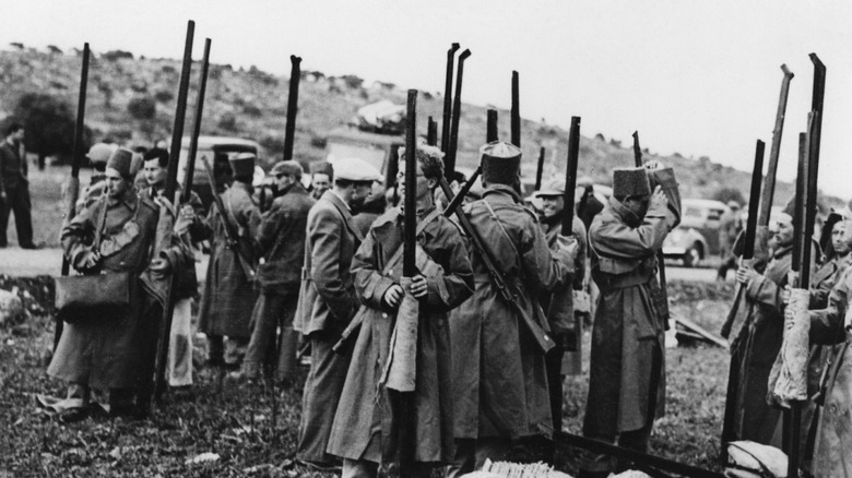 Soldiers with rifles standing in group