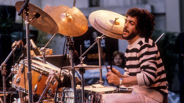 Steve Gadd playing drums in striped sweater at music festival