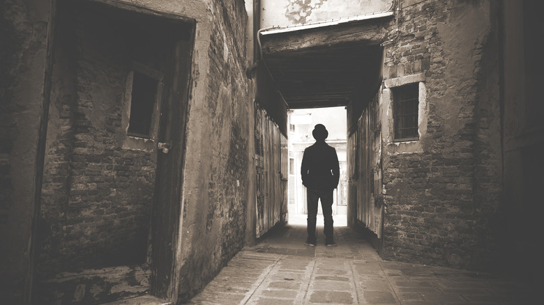 silhouette of man standing in alley