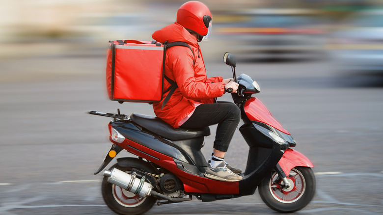 food delivery person driving a scooter